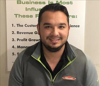 Man in SERVPRO fleece standing in front of SERVPRO sign