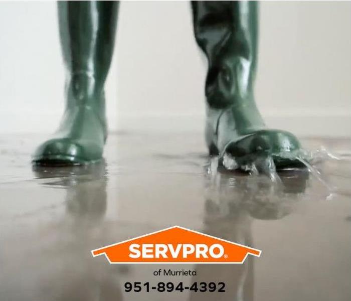 A person wades through a flooded room in a commercial building.