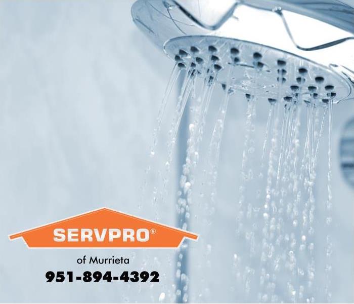 A shower head is shown with running water.