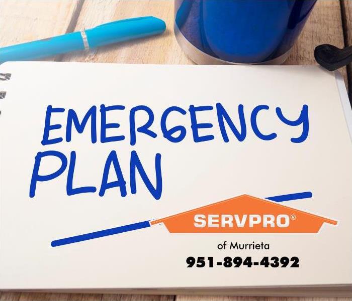 “Emergency plan” is seen written on a white notepad in blue ink.