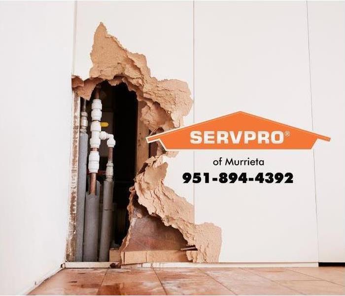 Damage to wall with pipes showing