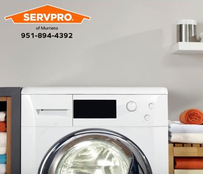 A washing machine is seen in a home laundry room.