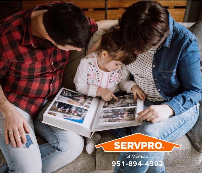 A family is looking at photographs in an album. 