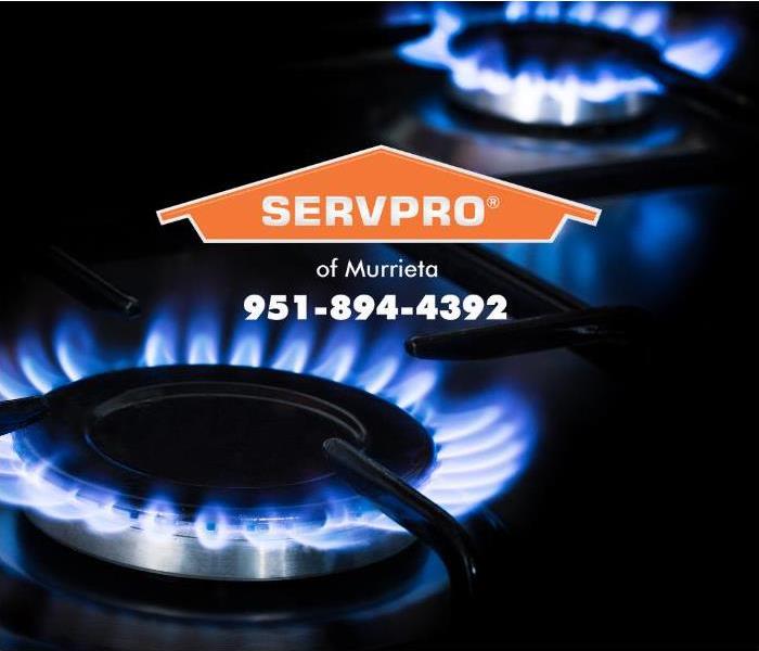 A lit gas burner on a stove in a home is shown.