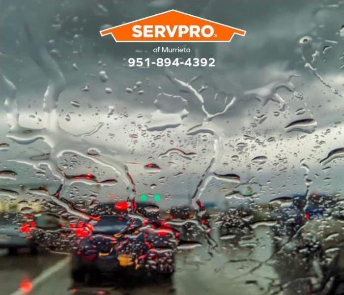 Rainwater on a windshield obscures a driver's view during a storm.