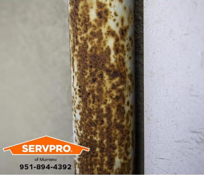 A corroded pipe is visible on the exterior of a home.